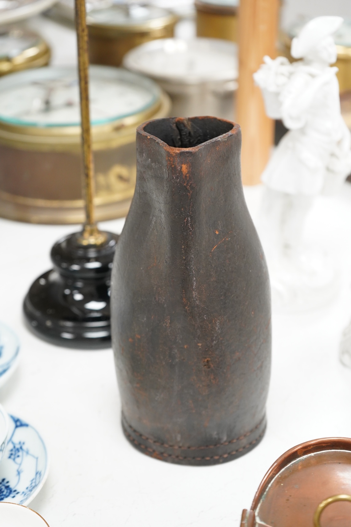 An adjustable wig stand, an oval copper box and a leather black jack jug, 24cm high.
